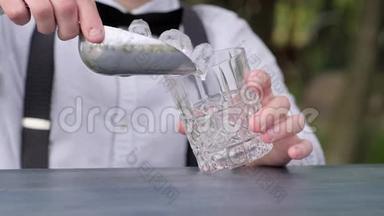 酒吧老板把冰块放进酒吧柜台的玻璃里，酒吧老板把冰块放进杯子里，用来喝酒，鸡尾酒会，
